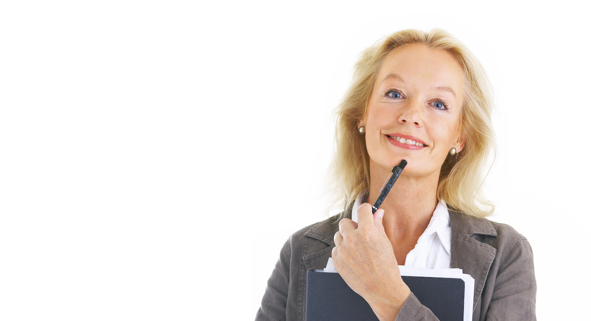 Person holding a pen to their cheek while smiling, with a black folder in hand.